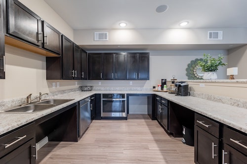 Wide view of a Manor, TX apartment kitchen with stainless steel appliances and granite countertops